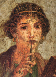 „Kobieta z woskową tabliczką i rysikiem (Safona)”, fresk, 37x38 cm, Narodowe Muzeum Archeologiczne w Neapolu, domena publiczna.